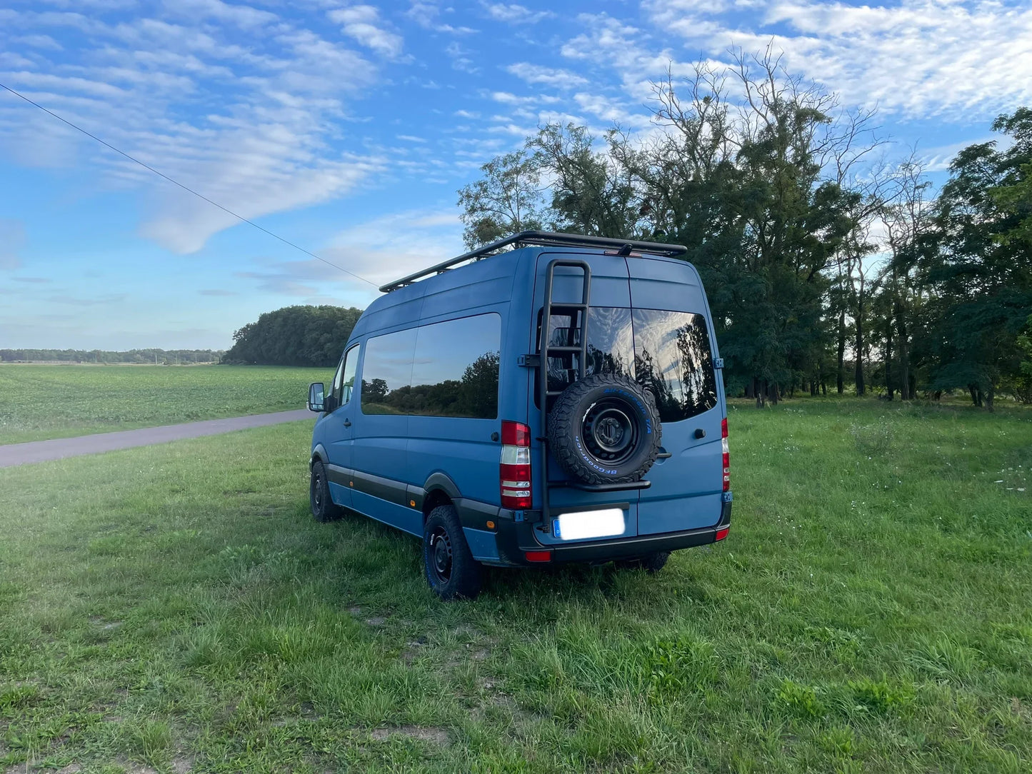 Eine Ersatzradleiter mit Reserverad und eine Leiter Dachträger aus Aluminium an einen Mercedes Sprinter